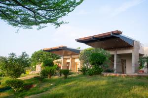 a house with a green lawn in front of it at Shlaka Farms in Jaipur