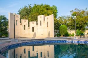 a building is reflected in a pool of water at Shlaka Farms in Jaipur