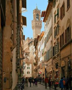 a group of people walking down a street with a clock tower at Relais Condotta in Florence