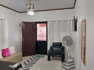 a living room with a chair and a door at Zoldyck Property in Pahanocoy