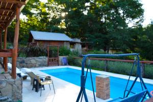 a swimming pool with a table and chairs next to it at Cabañas "La Quimera" in El Durazno