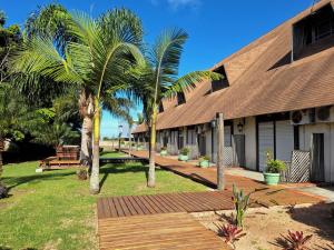 a building with palm trees in front of it at Pontal Tapes Hotel in Tapes