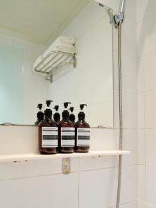 a row of bottles on a shelf in a bathroom at K9 Myeongdong Hotel in Seoul +27 photos
