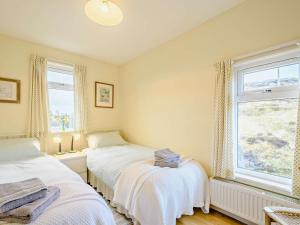 two beds in a room with a window at 4 Bed in Scourie oc-ca399 in Scourie