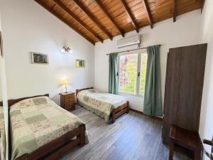 a bedroom with two beds and a window at VALERIA 4 Ambientes in Valeria del Mar