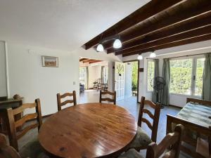 a dining room with a wooden table and chairs at VALERIA 4 Ambientes in Valeria del Mar