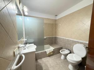 a bathroom with a toilet and a sink and a shower at VALERIA 4 Ambientes in Valeria del Mar +13 photos