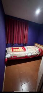 a bedroom with a bed with a red curtain at cris in Sierra de los Padres +8 photos