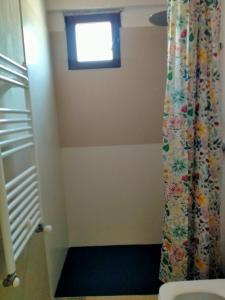 a bathroom with a shower curtain and a window at Vía Láctea Costa da Morte in Dumbría