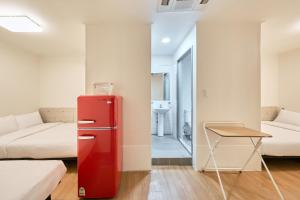 a red refrigerator in a room with a bed and a table at K9 Myeongdong Hotel in Seoul