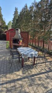 a patio with a table and two chairs and a stove at The Corner House Panzió in Tata