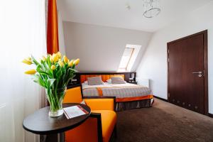 a hotel room with a bed and a vase of flowers on a table at Wieniawa in Leszno +54 photos
