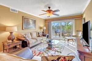 a living room with a couch and a ceiling fan at Palm Beach Landings A107 in Fort Myers