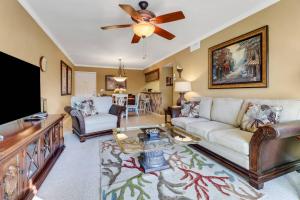 a living room with a couch and a ceiling fan at Palm Beach Landings A107 in Fort Myers