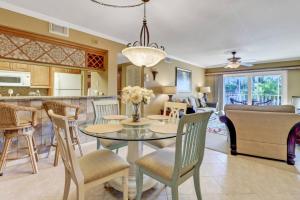 a dining room and living room with a table and chairs at Palm Beach Landings A107 in Fort Myers