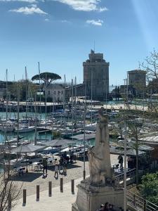 a statue in front of a marina with boats at Hôtel Le Yachtman, The Originals Collection in La Rochelle +59 photos