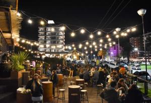 a group of people sitting at tables under lights at Vicco in Pinamar