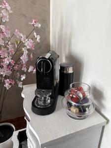 a coffee maker on a table next to a bowl of candy at Viola Apartment Monte Felice in Bardolino +15 photos