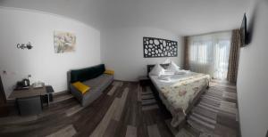 a room with a bed and a couch in it at Pensiunea Emage Moieciu in Moieciu de Sus