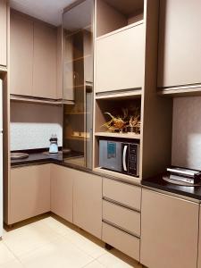 a kitchen with white cabinets and a microwave at Casa Pires - Sinop MT in Sinop