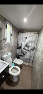 a bathroom with a toilet and a sink at Toby in Sierra de los Padres