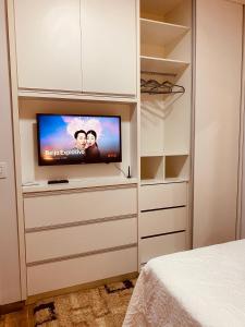 a bedroom with a tv in a white closet at Casa Pires - Sinop MT in Sinop