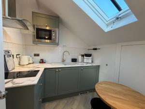 a kitchen with green cabinets and a sink and a table at Grangeview Guest House in Edinburgh