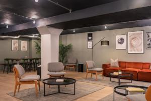 a waiting room with couches and chairs and tables at Zedwell Underground Hotel Tottenham Court Rd in London