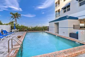 a swimming pool with blue chairs and a building at Estero Island Beach Villas 105 in Fort Myers Beach