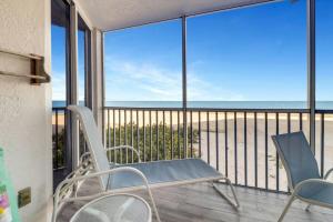a balcony with chairs and a view of the ocean at Estero Island Beach Villas 105 in Fort Myers Beach