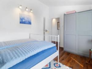 a white bedroom with a bed and a closet at El Dorado in Premantura