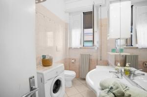 a bathroom with a washing machine and a sink at Follonica Vacanze 7 in Follonica +19 photos