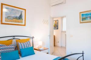 a bedroom with a bed with blue and orange pillows at Follonica Vacanze 7 in Follonica