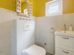 a bathroom with a white toilet and a sink at El Dorado in Premantura +35 photos