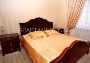 a bedroom with a large bed and a night stand at Delight Сая in Astana
