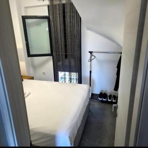 a bedroom with a white bed and a window at Diamond Deluxe Loft in Iraklitsa