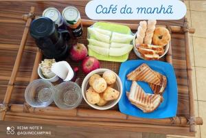 a tray of food with apples and bread and snacks at Aqui no Camping in Brumadinho