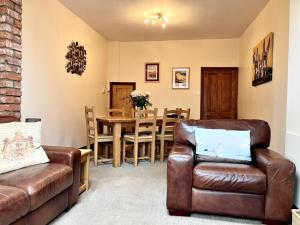 a living room with a couch and a dining room at Fiona's House in Filey