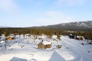a house in the snow with trees and mountains at Orrmötesvägen 21 - Funäsdalen in Funäsdalen