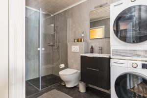 a bathroom with a shower and a toilet and a washing machine at Orrmötesvägen 21 - Funäsdalen in Funäsdalen