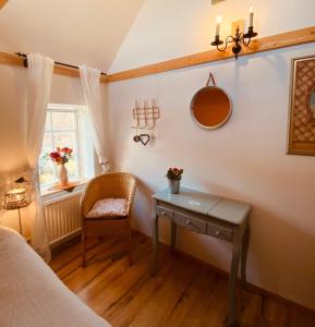 a bedroom with a table and a chair and a window at Skrattande Ko in Tingsryd