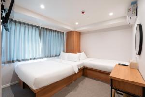 a small bedroom with two beds and a desk at KIMSTEL Jongno in Seoul