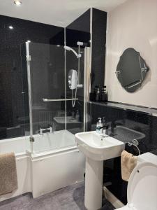 a bathroom with a shower and a sink and a toilet at The Penthouse- The Kingsley Collection in Troon +37 photos