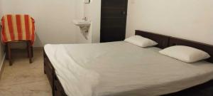 a bed with two pillows and a chair in a room at Matha homestay Vattavada in Vattavada