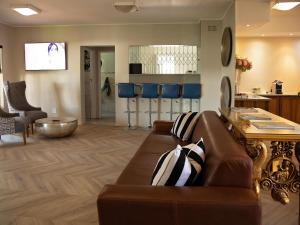a living room with a brown couch and a table at Stay in Postmasburg