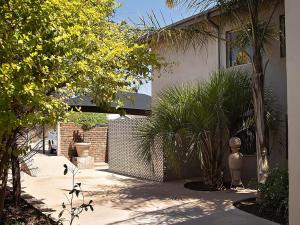 a courtyard with palm trees in front of a building at Stay in Postmasburg