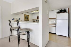 a kitchen with two chairs and a white refrigerator at 4111 Gunnison Ct #1214 in Estero +39 photos