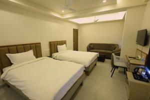 a hotel room with two beds and a chair at Hotel Rock Port Inn in Rushikonda