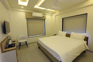 a bedroom with a bed and a tv in it at Hotel Rock Port Inn in Rushikonda +43 photos