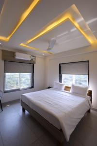 a bedroom with a large bed with white sheets at Hotel Rock Port Inn in Rushikonda